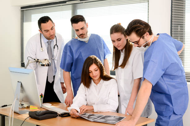 group of surgeons and medical professional staff discussing on patient radiography outside hospital operating room group of surgeons and medical professional staff discussing on patient radiography outside hospital operating room surgical light stock pictures, royalty-free photos & images