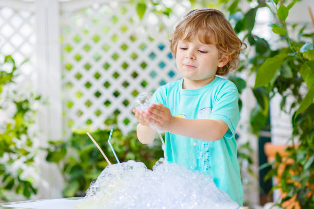 istock Happy little boy making experiment with colorful water and soap 678718810