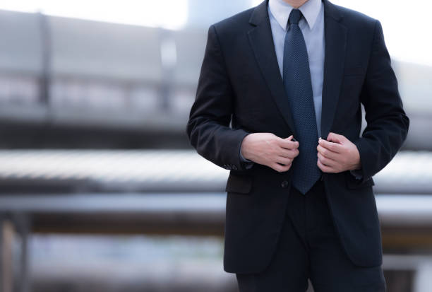 istock Cheerful young man in suit is preparing for an appointment. He is standing and touching his jacket. Isolated and copy space in right side 678728048
