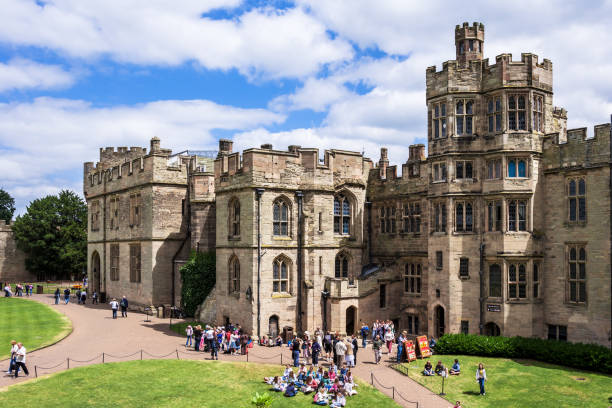 View of the medieval Warwick Castle. Warwickshire, England Warwick, Warwickshire, United Kingdom - June 21, 2006: View of the medieval Warwick Castle from within the castle gardens and people enjoying the setting. warwick uk stock pictures, royalty-free photos & images