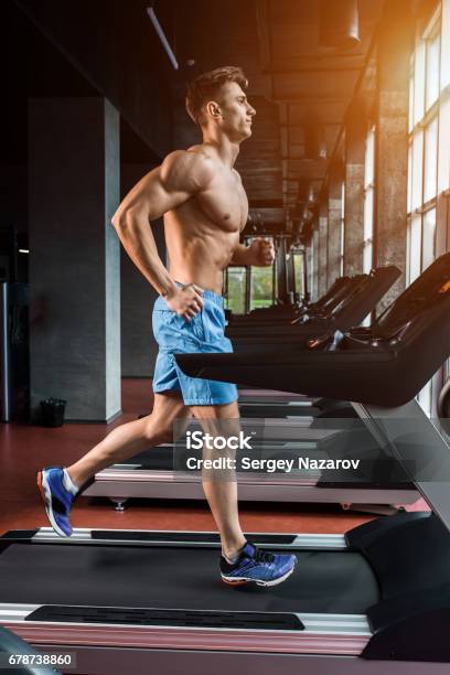 Young Adult Man Running On Treadmill In Gym Stock Photo - Download Image Now - Treadmill, Active Lifestyle, Adult