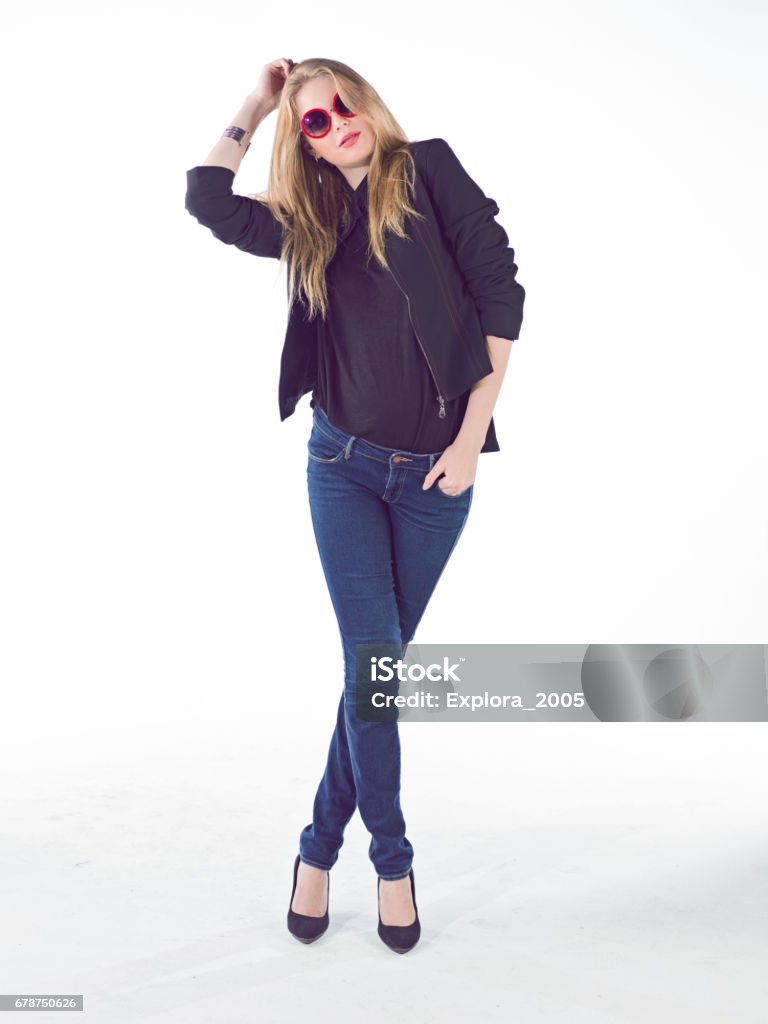 beautiful young woman wear blue jean and sunglasses beautiful young fashion girl posing at studio. Lady wear blue jean pant and black jacket with red sunglasses. 20-29 Years Stock Photo