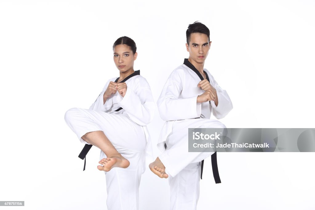 Two man and woman Master Black Belt TaeKwonDo Teacher show fighting session kick and pounch Two man and woman Master Black Belt TaeKwonDo Teacher show fighting session kick and pounch, studio lighting white background. concept fight together Adult Stock Photo
