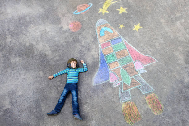 little kid boy flying by a space shuttle chalks picture - child chalking imagens e fotografias de stock