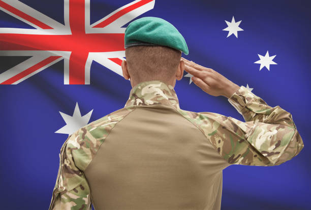 Dark-skinned soldier with flag on background - Australia stock photo