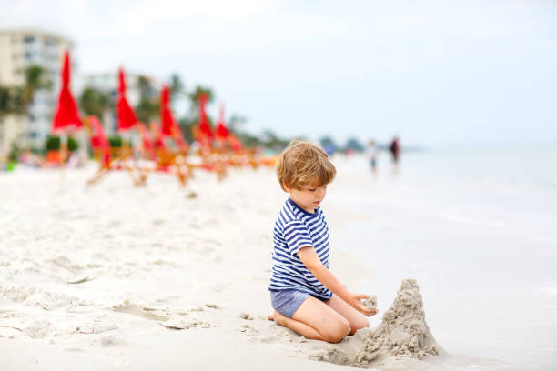 istock Little kid boy having fun with building sand castles 678753922