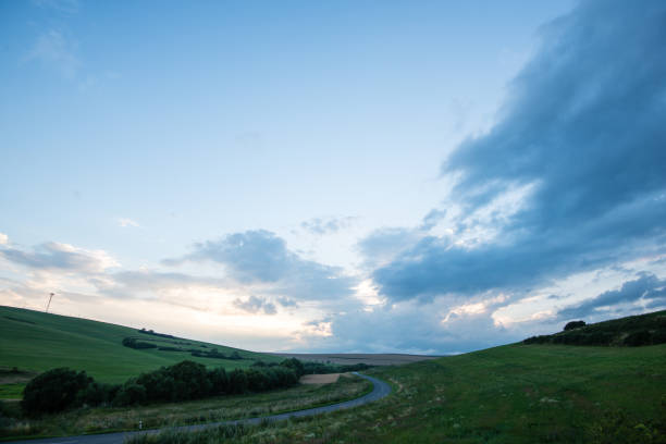 istock Dark storm clouds over meadow with green grass 678771944