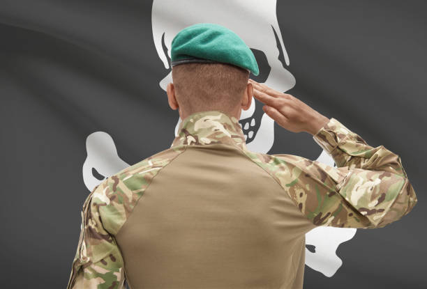 istock Dark-skinned soldier with flag on background - Jolly Roger 678775528