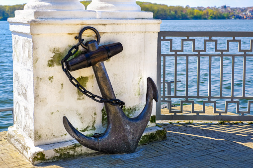 istock Old vintage rusty anchor in the park near lake 678776090
