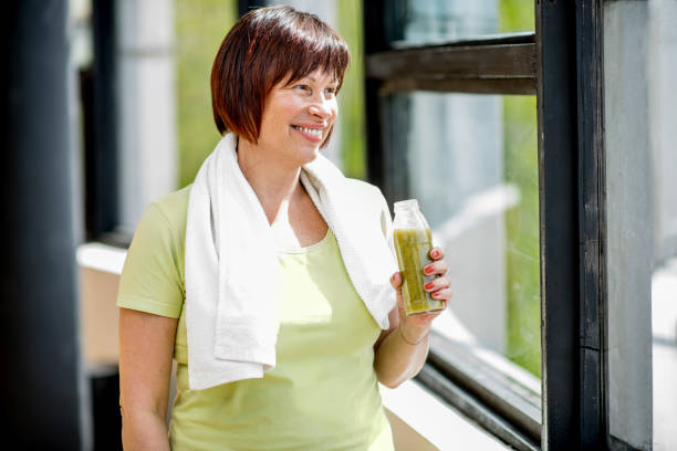 istock Older woman with smoothie indoors 678798014