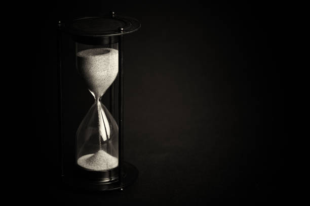 istock Large black hourglass against a black background 678798478