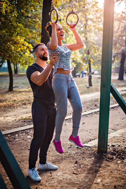 istock Man helping girl to do pull ups on rings 678799988