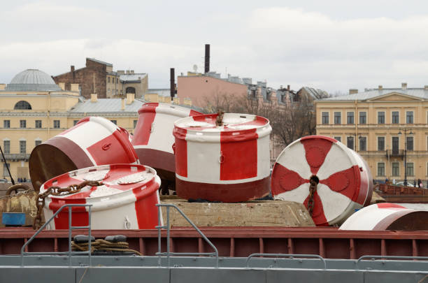 large marine buoys lie in a pile at the pier.