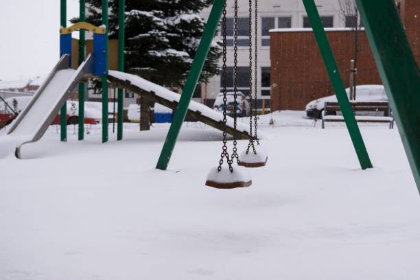 istock Swing on playground covered by snow during winter. 678822944