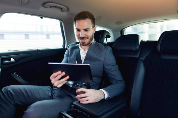 istock Businessman in a car using digital tablet and smiling. 678836230