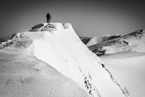 istock Man top of snowy mountain ridge 678837826