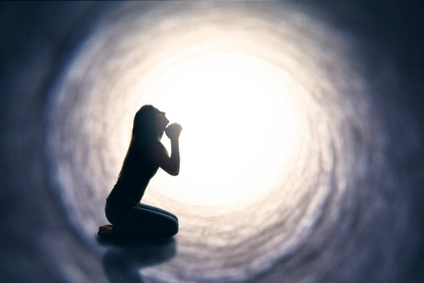 istock Woman Kneeling And Praying In Tunnel 678853438