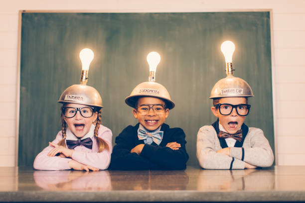 trois jeunes nerds avec bouchons de pensée - blackboard child thinking little girls photos et images de collection