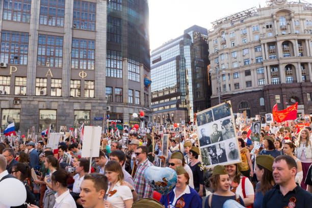 processione del reggimento immortale nel giorno della vittoria - migliaia di persone che marciavano lungo via tverskaya verso la piazza rossa con bandiere e ritratti in commemorazione dei loro cari che combatterono nella seconda guerra mondiale - nationwide foto e immagini stock