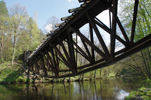 Destroyed railway bridge over the river, in the woods