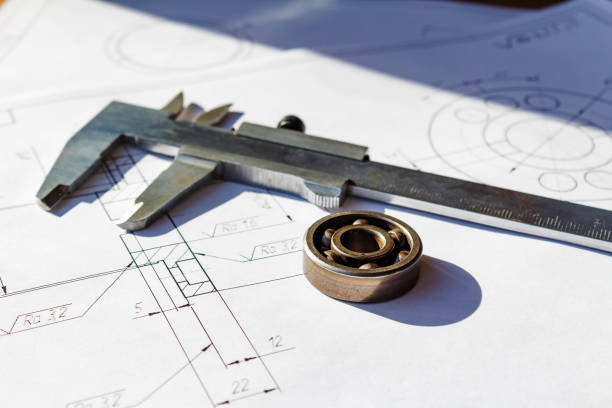 istock Slide caliper and ball bearing lie on a drawings 678877464