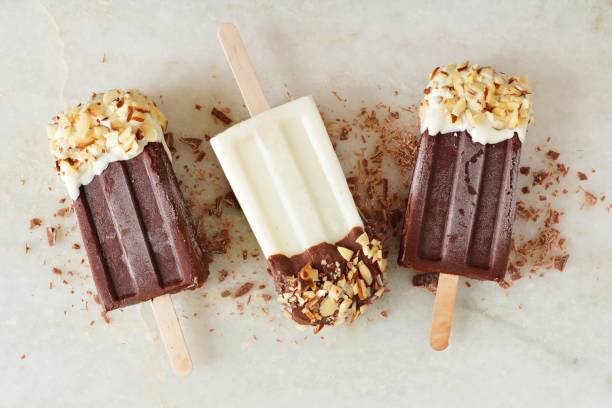 Chocolate and almond dipped popsicles, over marble