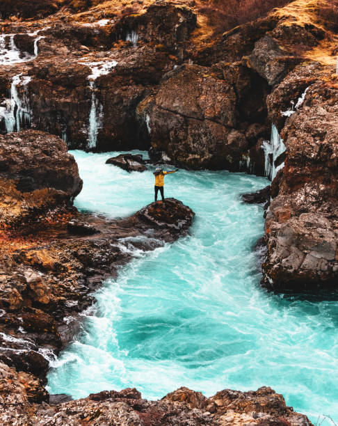istock man on the iceland hraunfossar waterfalls 678938430