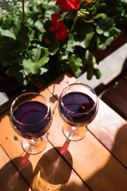 two glasses of red wine on the vibrant restaurant background. selective focus. - bentham imagens e fotografias de stock