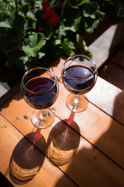 two glasses of red wine on the vibrant restaurant background. selective focus. - bentham imagens e fotografias de stock