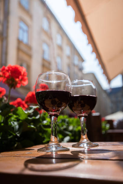 two glasses of red wine on the vibrant restaurant background. selective focus. - bentham imagens e fotografias de stock