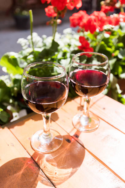 two glasses of red wine on the vibrant restaurant background. selective focus. - bentham imagens e fotografias de stock