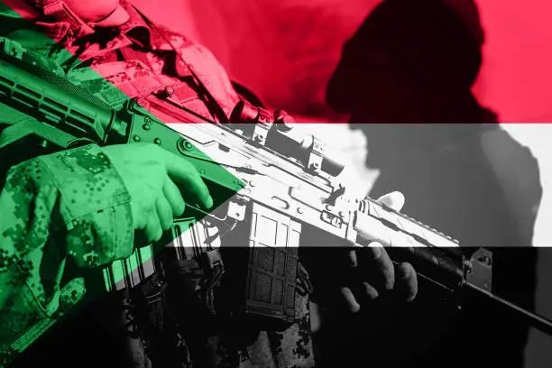 Photo of Soldier with machine gun with national flag of Sudan
