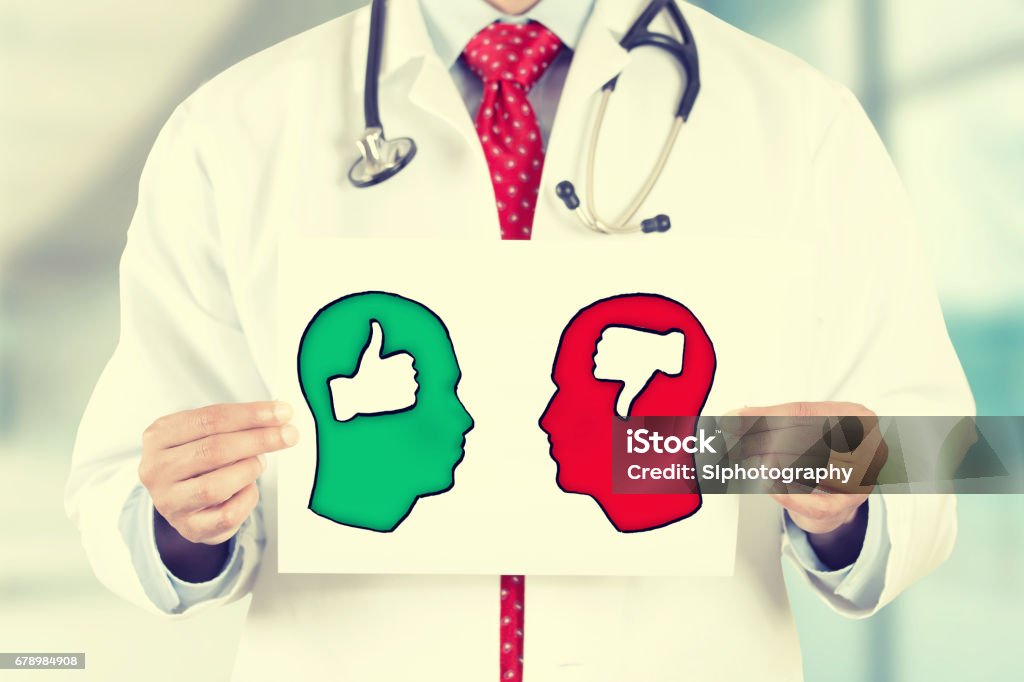 doctor hands holding white card with green red thumbs up thumbs down symbols inside signs shaped as human head Closeup doctor hands holding white card with green red thumbs up thumbs down symbols inside signs shaped as human head isolated on hospital clinic office background. Retro instagram style filter image Doctor Stock Photo