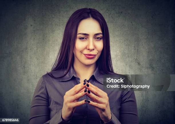 Woman Looking With Sly Expression Having Good Idea Stock Photo - Download Image Now