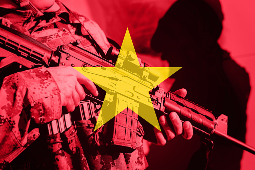 Soldier with machine gun with national flag of Vietnam
