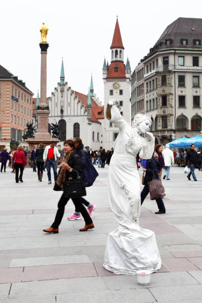 Munich, Germany - April 29, 2013: Walking people and street artist on Marienplatz square in Munich