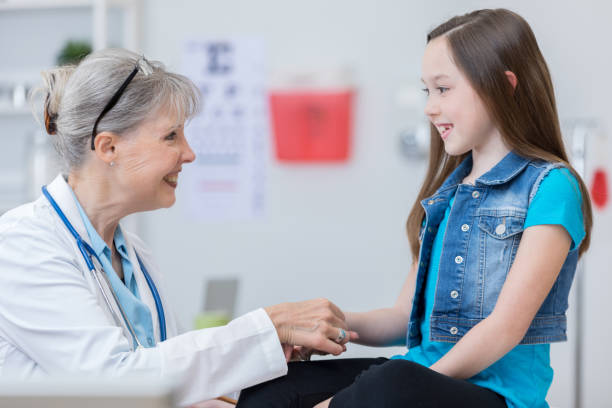 istock Senior pediatrician talks with young patient 679028406