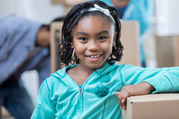 istock Happy young girl smiles while helping her family pack 679028454