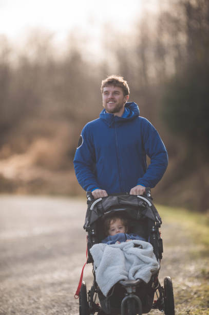 istock Young dad pushing baby stroller outside 679097904