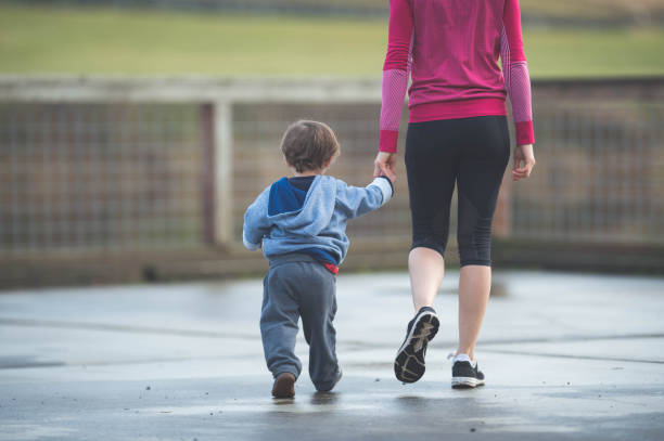 istock Young active Eurasian mom outside walking with two-year old son 679097906