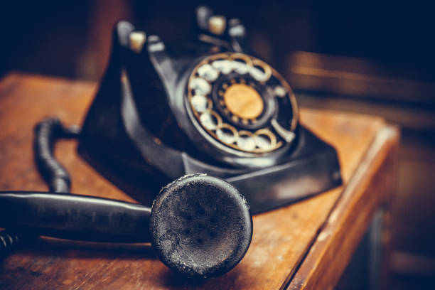 istock Vintage black phone on old wooden table background 679136592