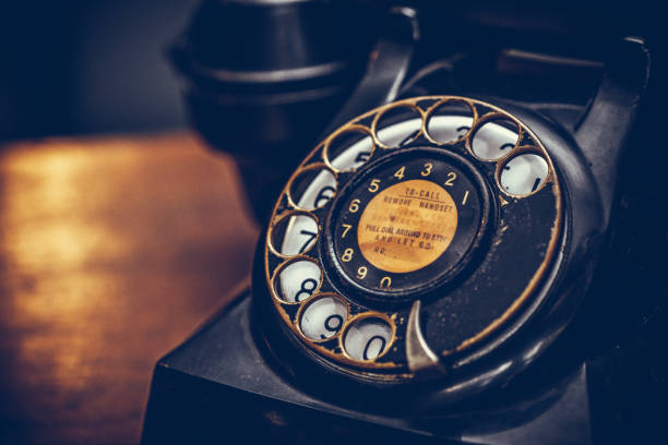 istock Vintage black phone on old wooden table background 679137824