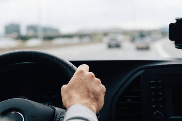 istock Man driving his car on the freeway. Focus on hand 679157196