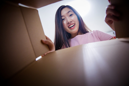 Young woman opening a parcel