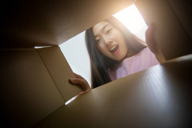 istock Young woman opening a parcel 679235062