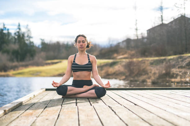 istock Young mom doing yoga outside by lake 679246638