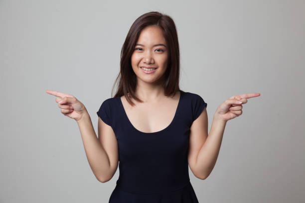 istock Young Asian woman point to left and right. 679252592