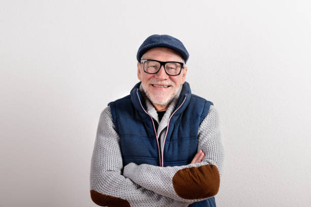 istock Senior man in sweater, vest jacket and cap, studio shot. 679253514