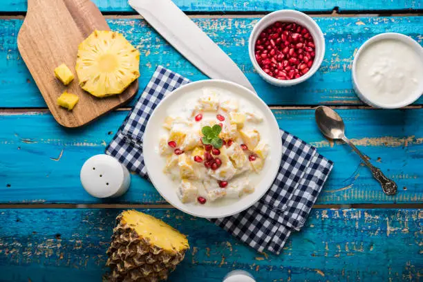 ananas or anaanaas or pineapple raita, chopped pieces of pineapple mixed with sweet curd and garnished with pomegranate and mint, favourite side dish or starter food in India