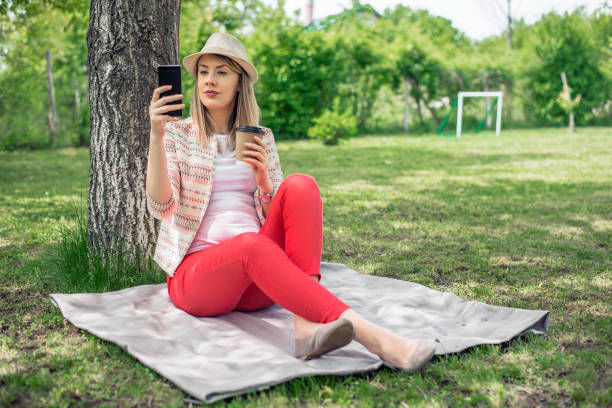 istock Woman relaxing at the park and using smart phone. 679270278
